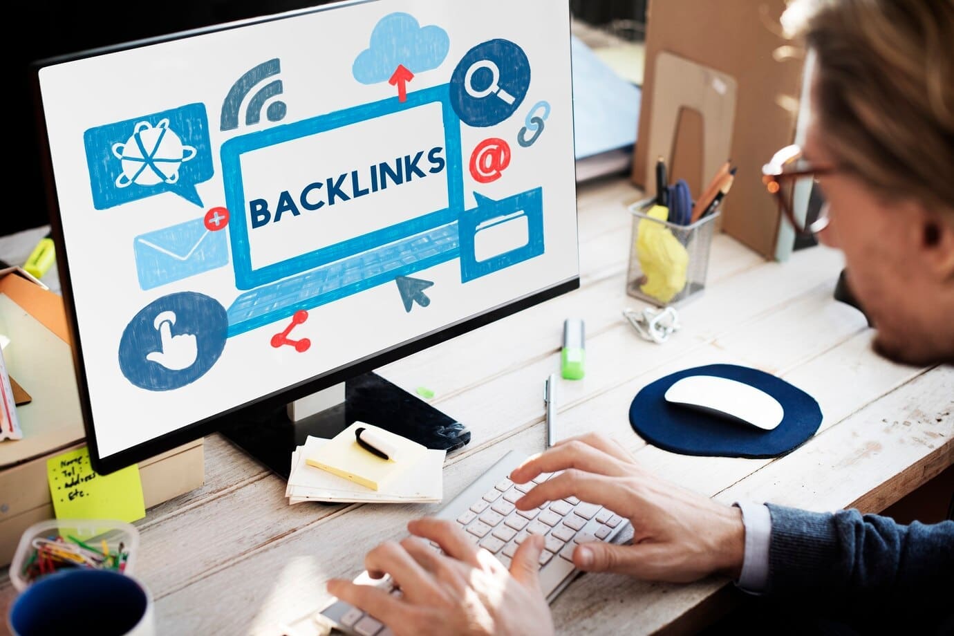 SEO vs PPC strategies showing a person analysing backlinks on a desktop screen for online marketing optimisation insights.